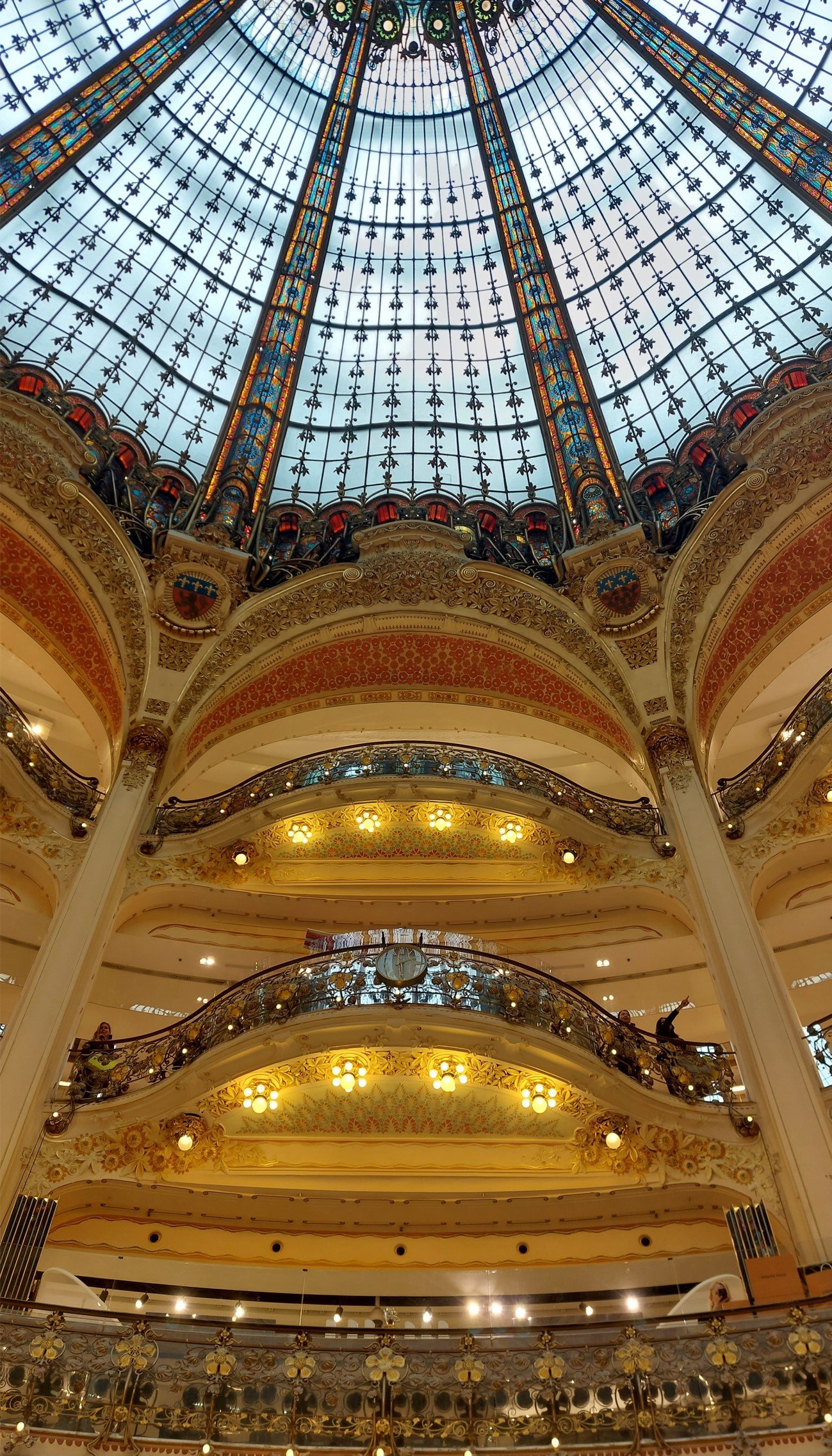 Magnificient golden balconies and glass dome with colors inside Galeries Lafayette Paris Haussmann